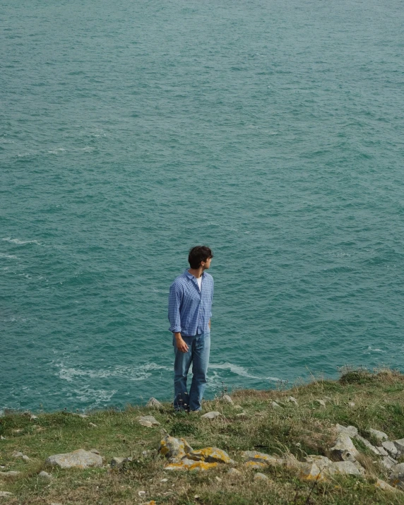 a man standing in front of a body of water