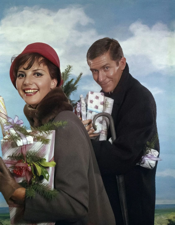 a couple holding christmas presents and smiling for the camera