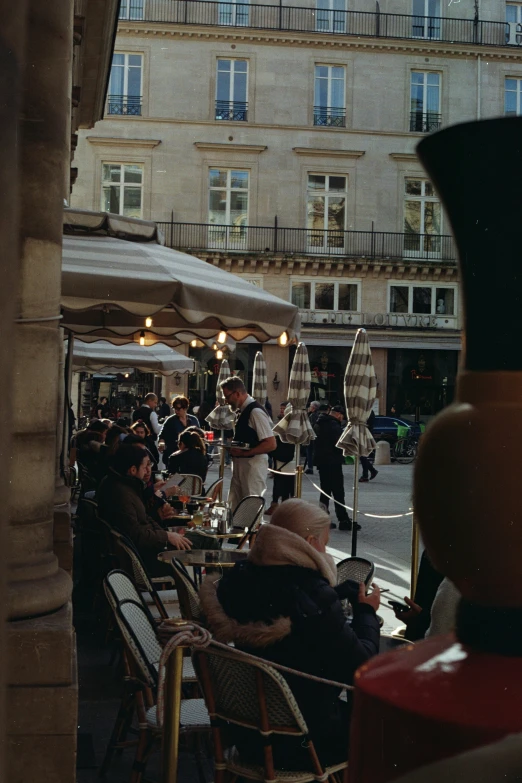 a crowded patio with chairs and tables full of people