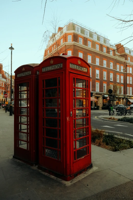 a red phone booth in the middle of a city