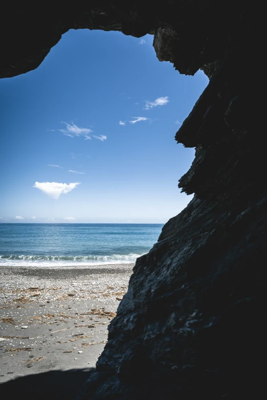 a view of an ocean from inside an arched cave