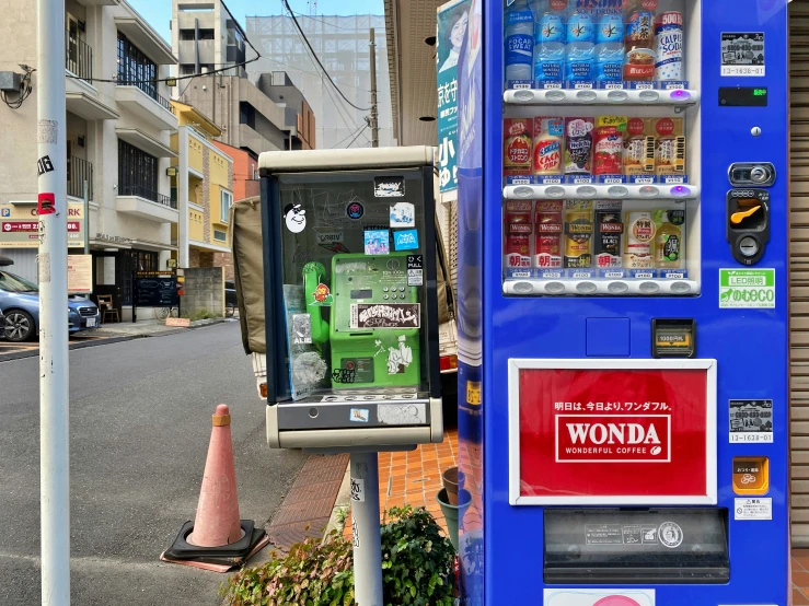 an empty blue vending machine on a city street