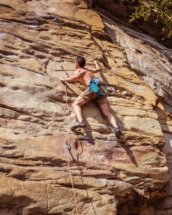 a man climbs up the side of a cliff