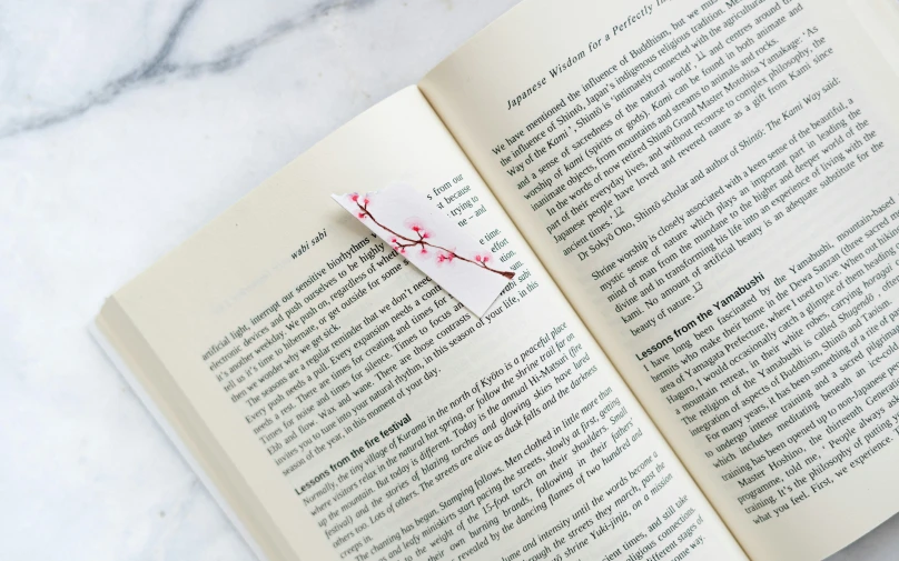 an open book with a red object hanging from the cover