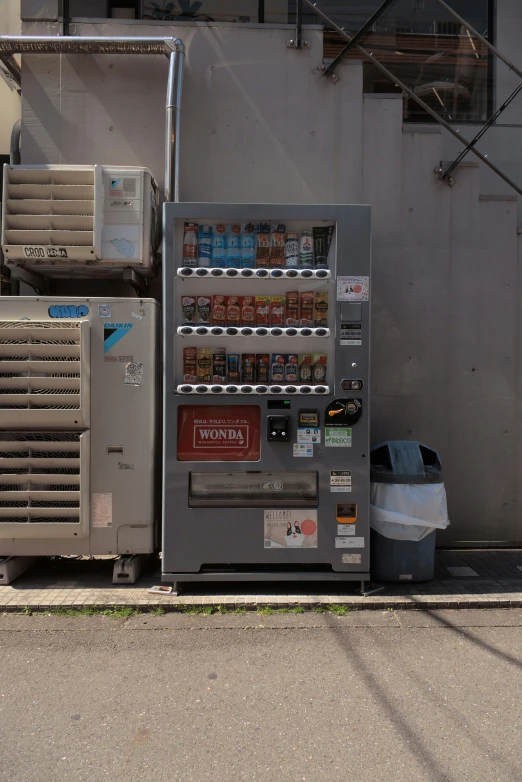 a vending machine and can of soda next to a metal wall
