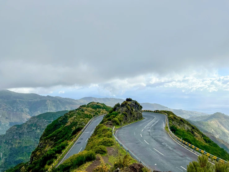 an winding road on top of a hill next to a mountain