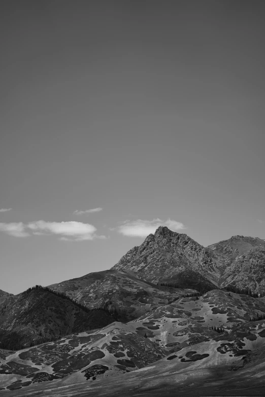 two mountains in the distance with a cloud in the sky