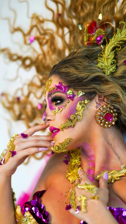 a woman with bright makeup and makeup is covered in gold and purple beads