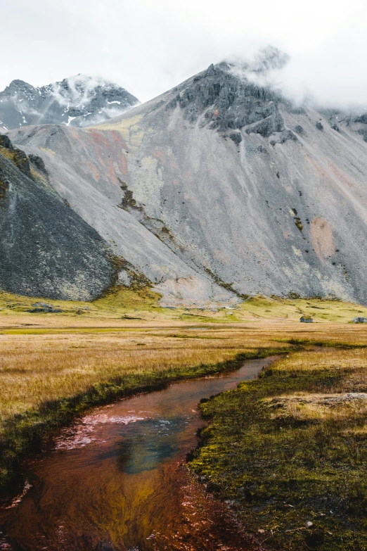 some mountains and water on a grassy plain