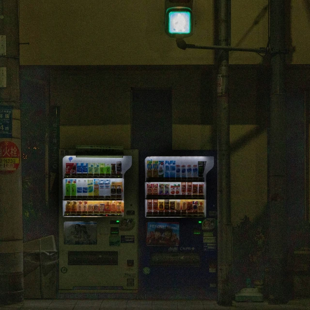 lighted vending machines at night in an industrial setting