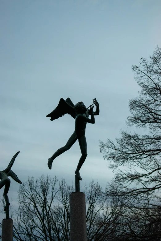 a statue is standing in the middle of a park