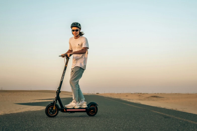 man on scooter in desert during sunset with sun glasses