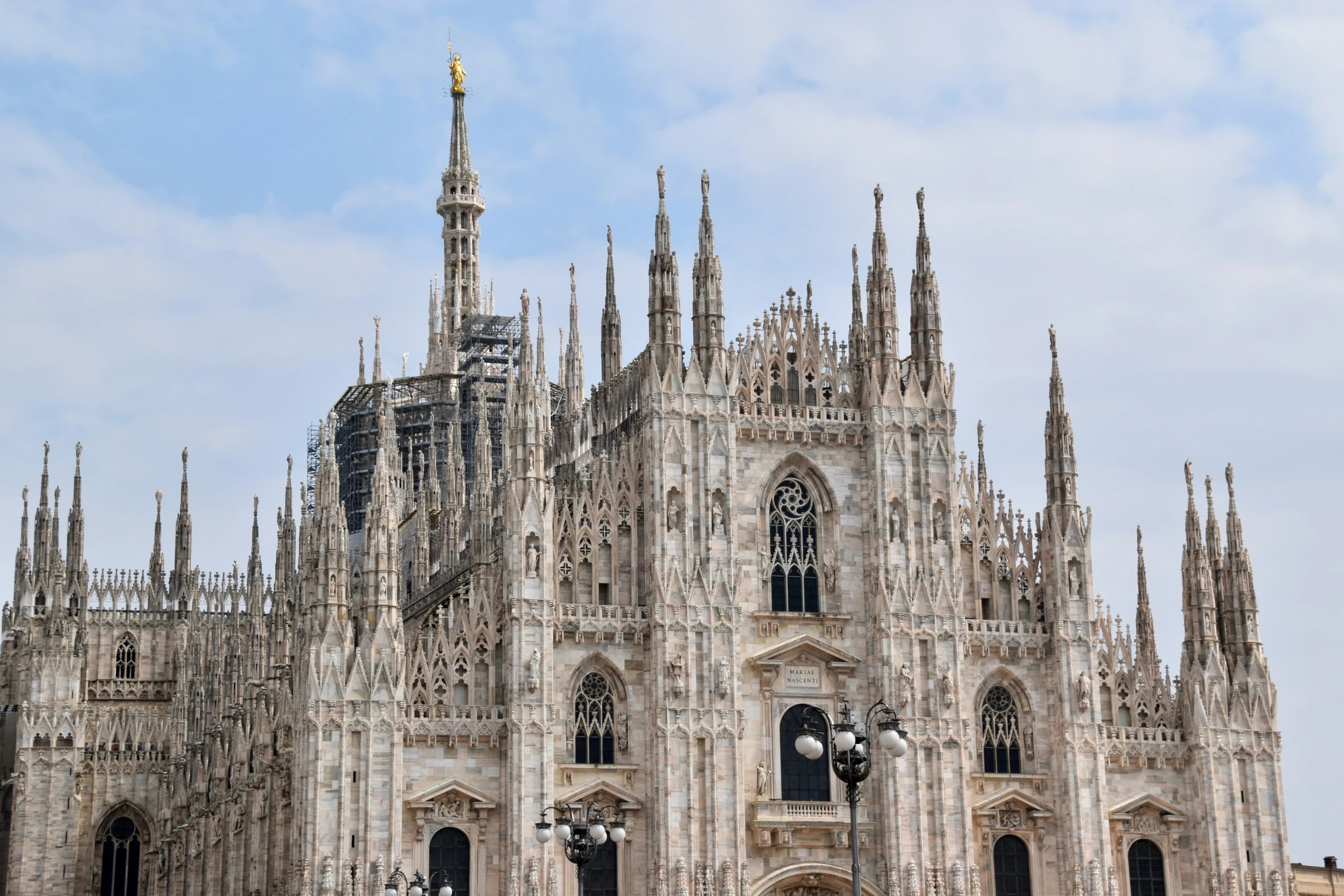 the cathedral has several spires and statues on it