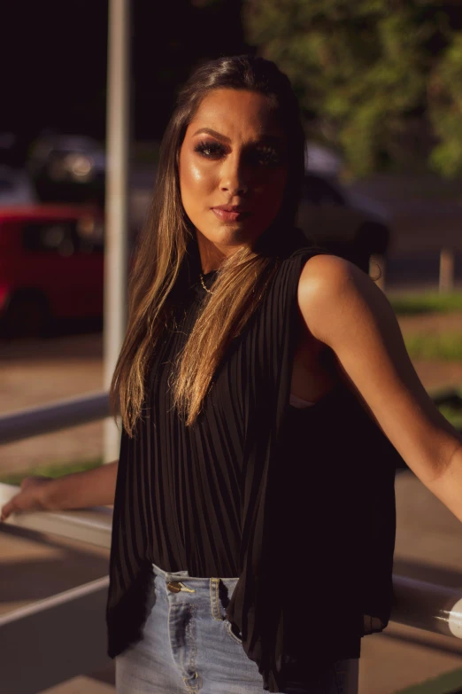 a beautiful woman in black top standing outside