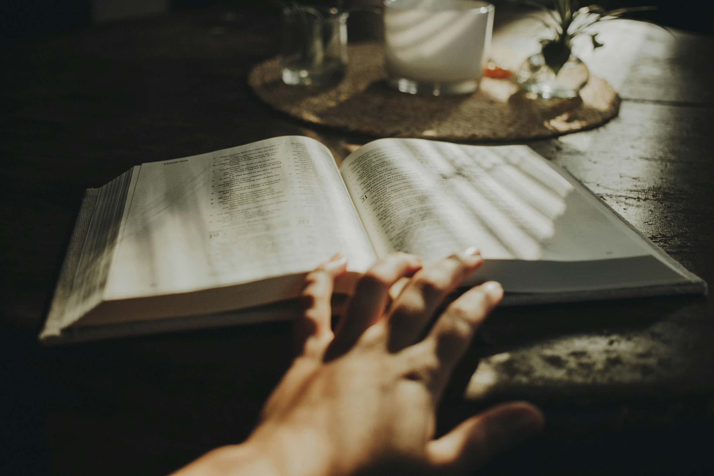 the person is reading the bible at the table