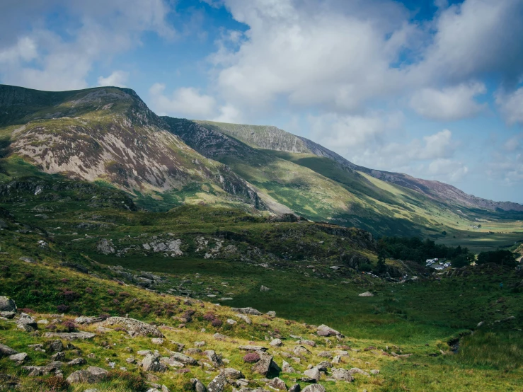 several mountains with green grass and rocks near them