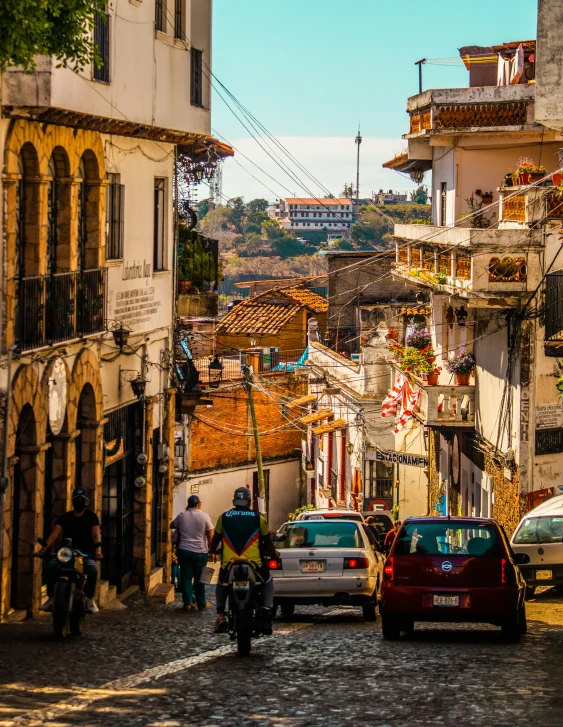 a very narrow and cobble stone road next to tall buildings