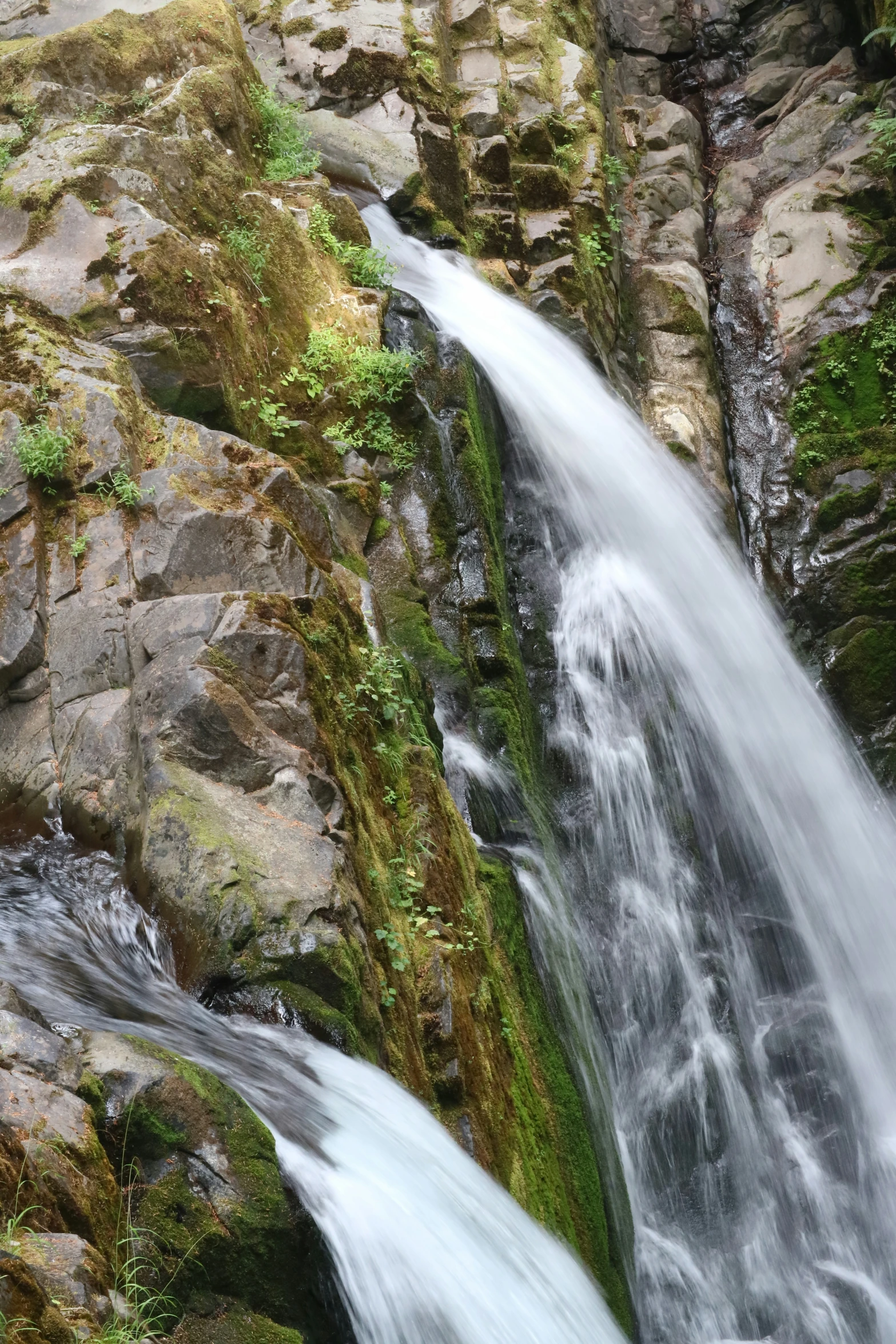 a small waterfall running over the top of a rocky cliff