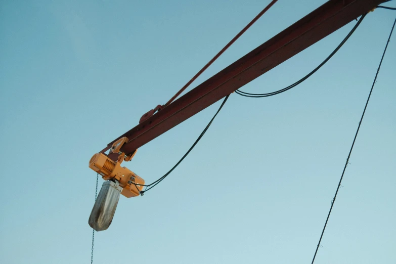 two orange electrical wires with sky in background