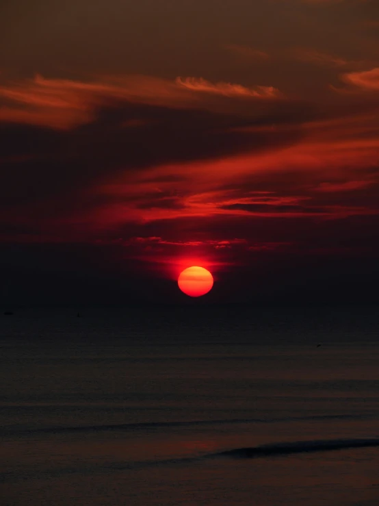 a red and orange sunset in the sea