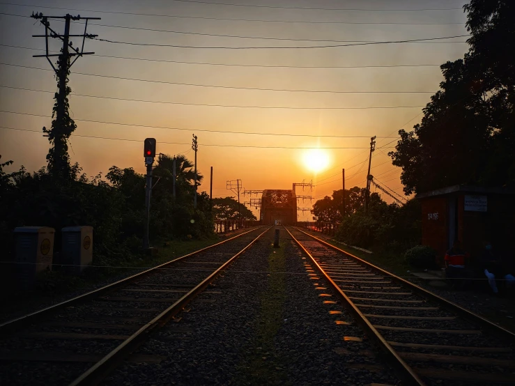 a set of train tracks leading to the sunset