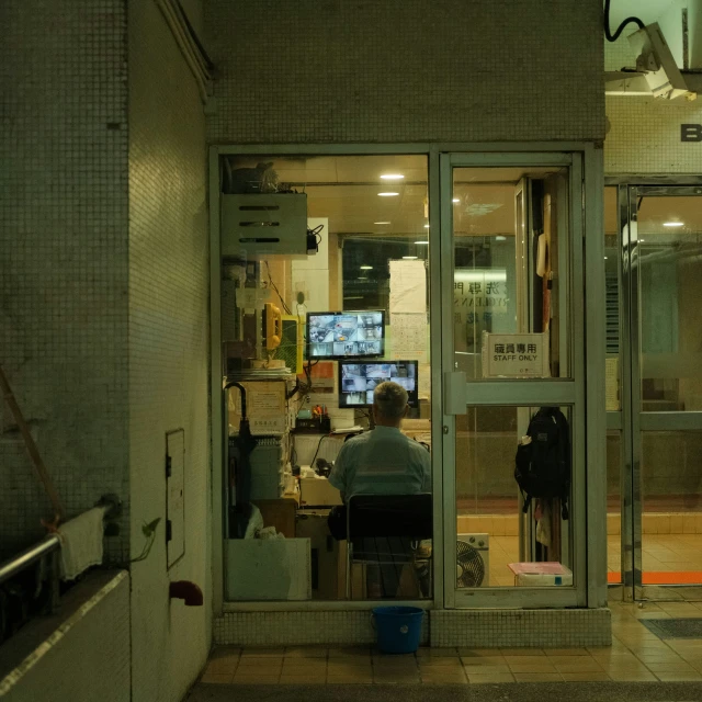 two people sitting in a room with televisions on