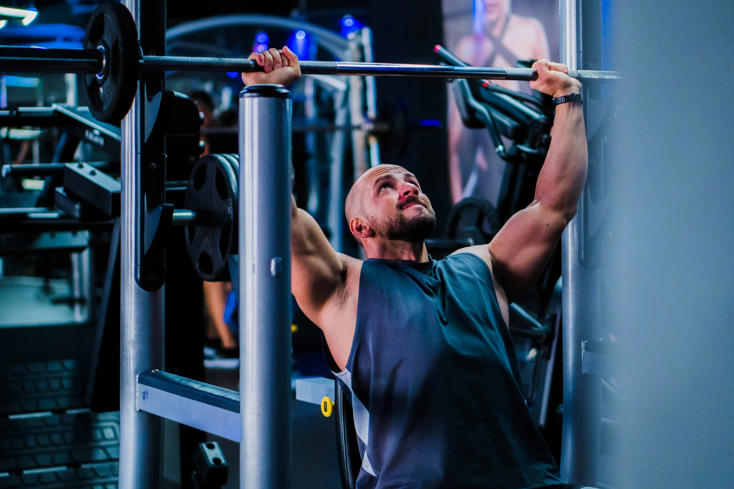 a man is lifting a bar in a gym