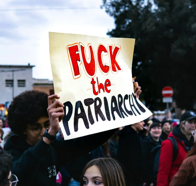 a protest is held with various people standing and holding signs