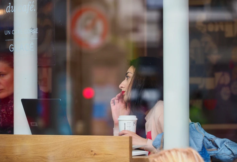 a woman talking on the phone sitting in a restaurant