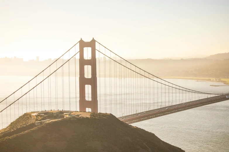 a man walking on a hill near the golden gate bridge