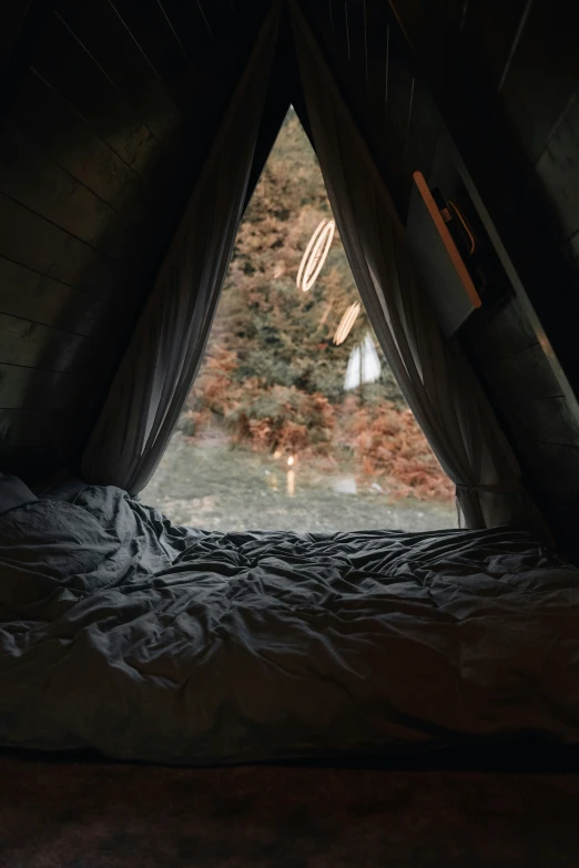 a bed with a pillow on it inside of a tent