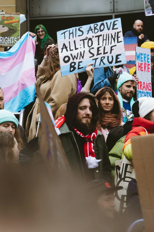 a group of people holding up signs and hats