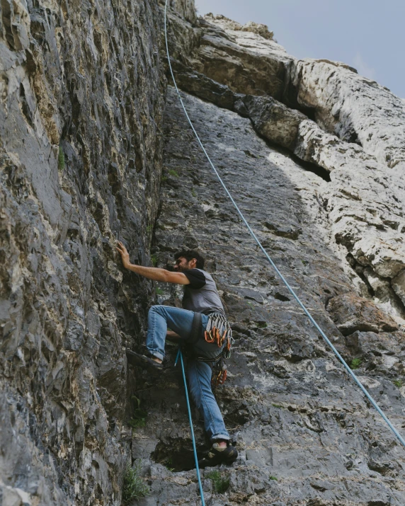 a man sitting on top of a rock climbing wall