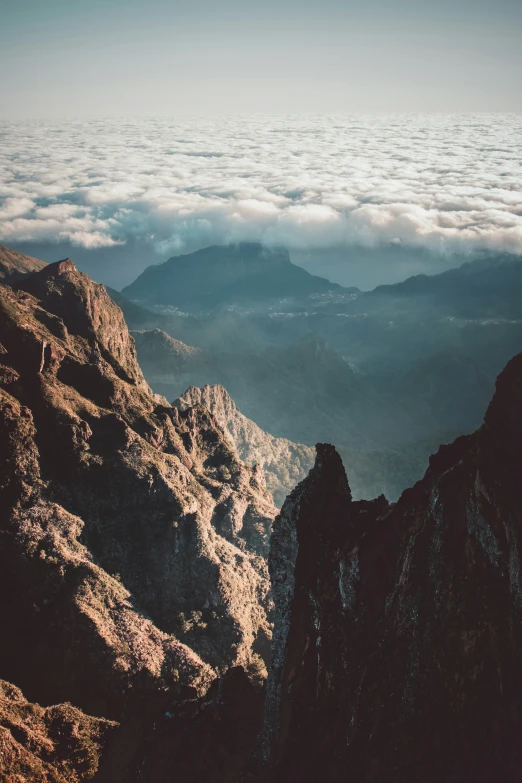 a mountain ridge with low clouds and light brown color