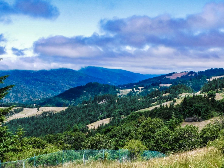 mountain with rolling hills with clouds and sky