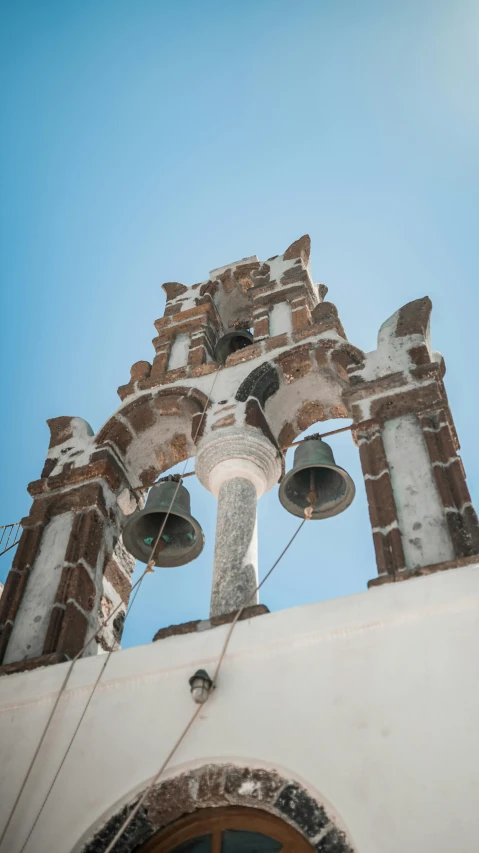 the tower top of a building has bells and two bells