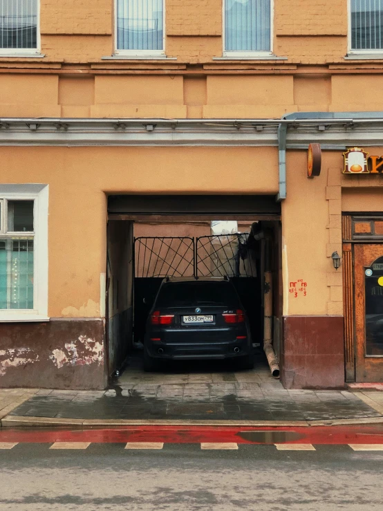 an old building with a car parked in the doorway