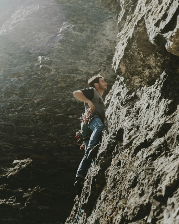 man climbing up side of mountain on rocks