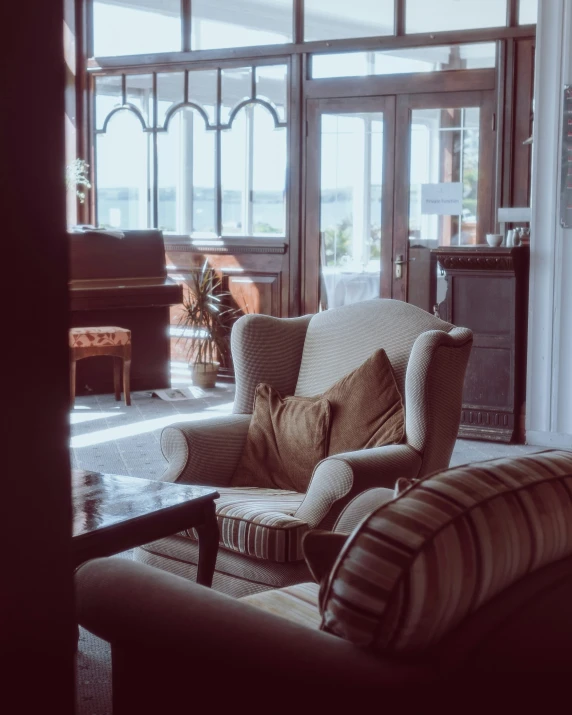 a large brown sofa sits in the center of a room with open doors leading to other rooms