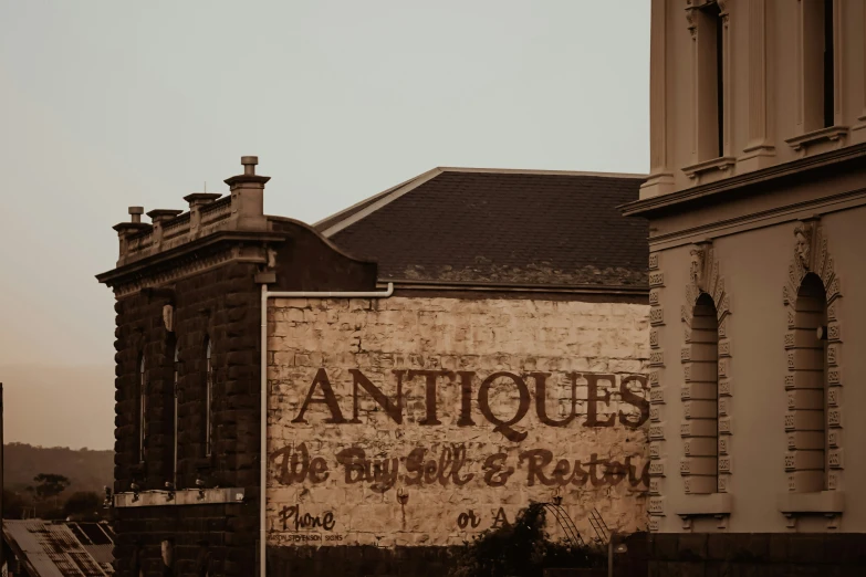 old brick building with a faded sign that says antiques