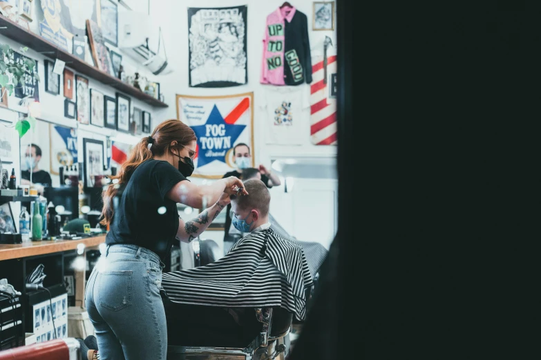 a woman is getting her hair cut by the barber