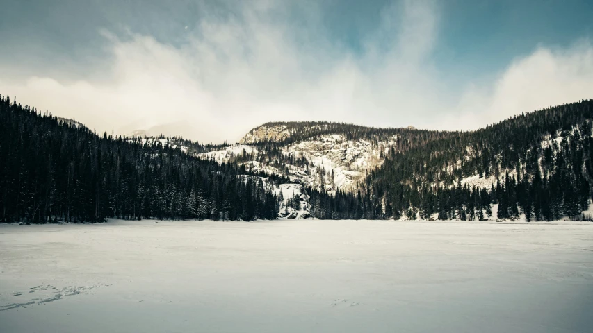 the snow is covering a flat surface in the mountains