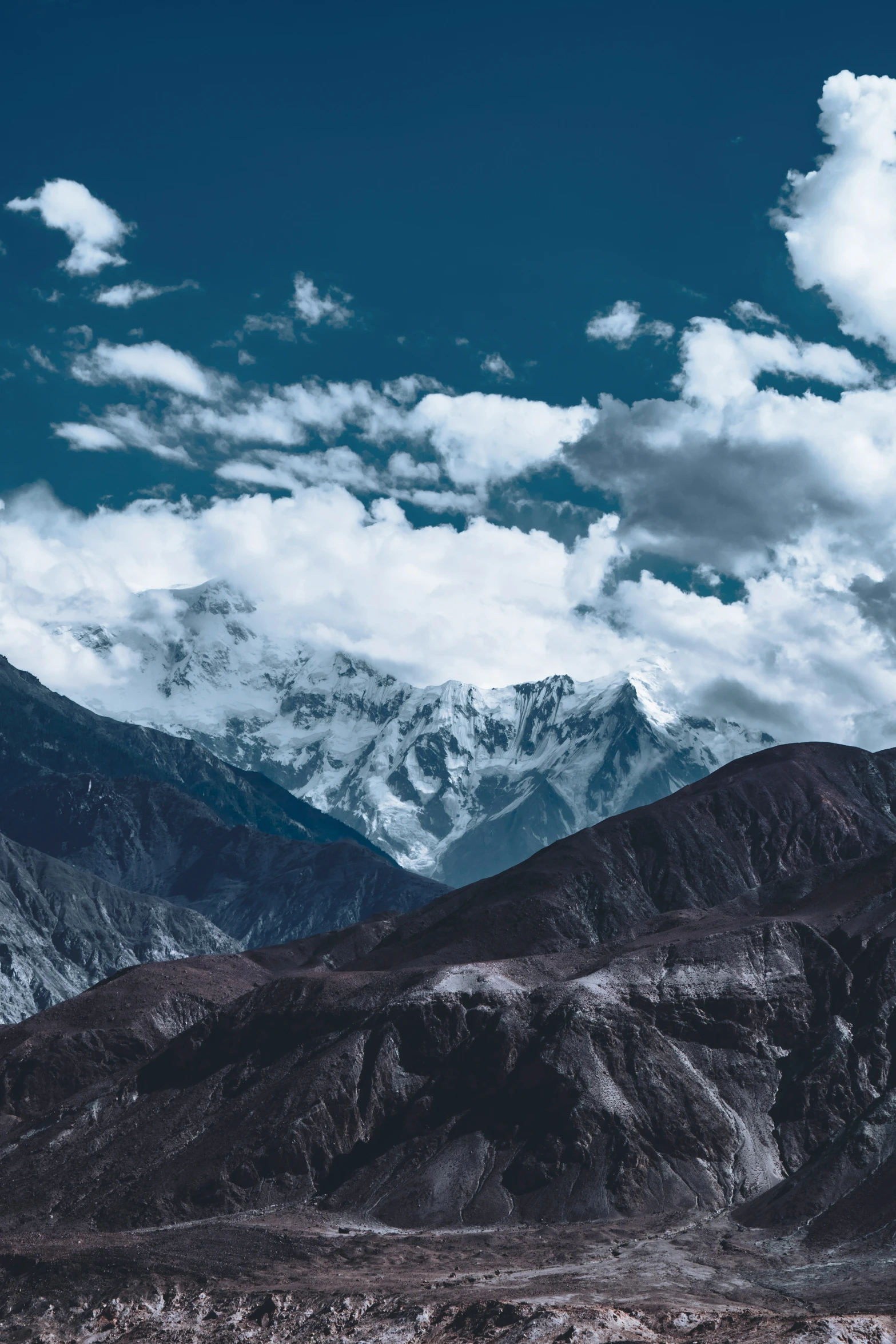 a snowy mountain with snow and clouds in the sky