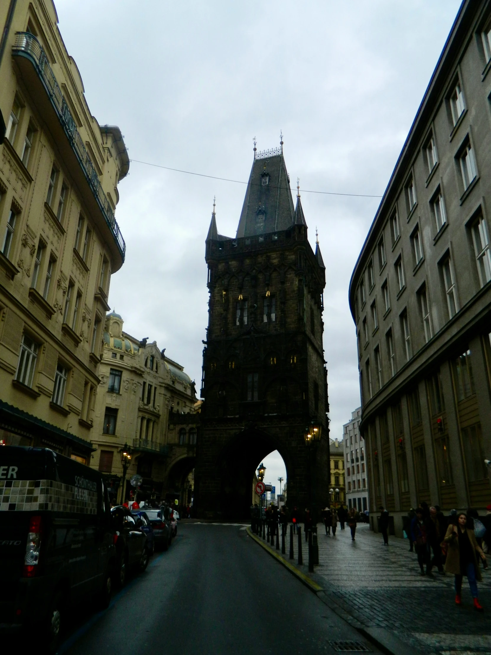 a tall building with a clock tower next to some cars