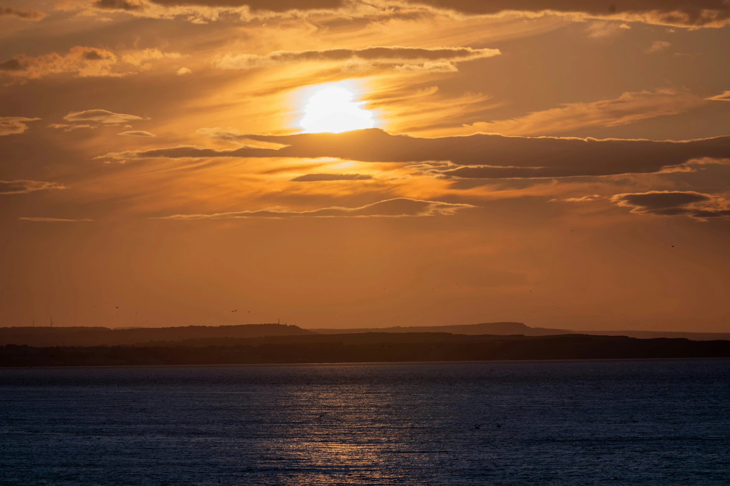 a sunset view shows the light reflecting off the water and the island