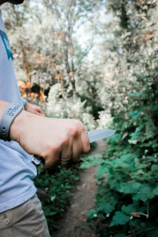 a person wearing a celet holding a knife