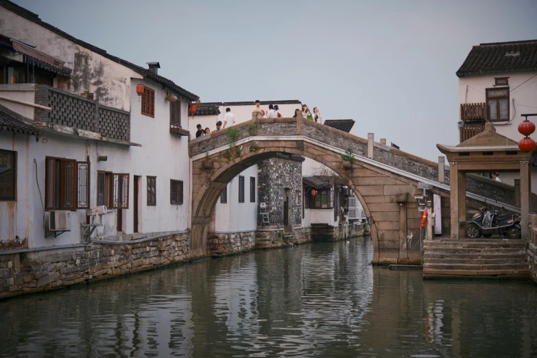 a bridge spanning over a river between two buildings