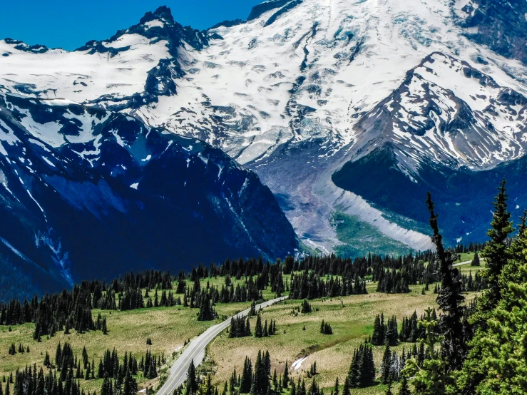 a mountain covered in snow with a road running through it