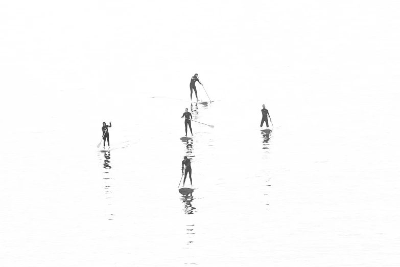 a group of people walking along a sandy beach next to a tall umbrella