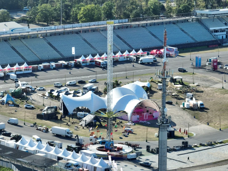 an aerial view of a carnival park in the middle of a dirt lot